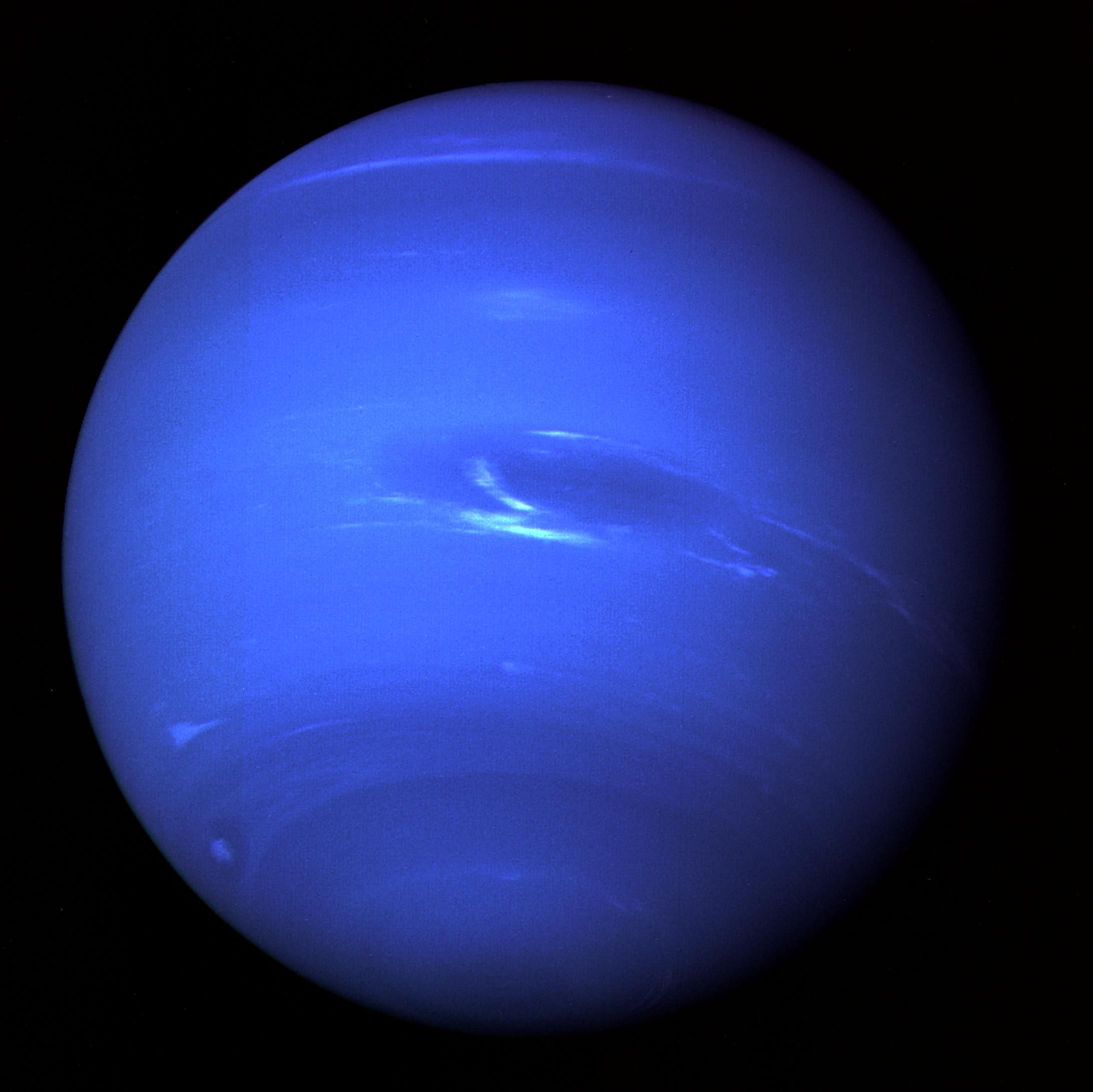 Neptune and its Great Dark Spot, a deep blue globe imaged by Voyager 2