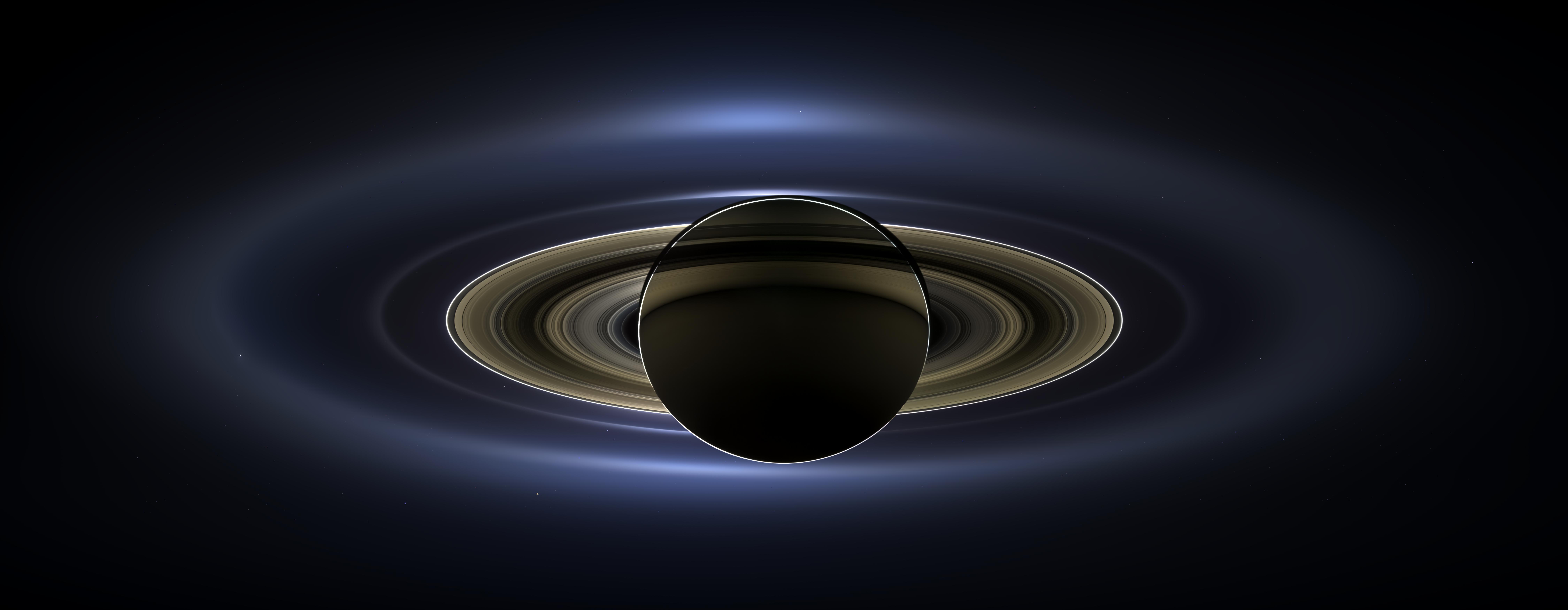 Saturn backlit by the Sun with its rings glowing, the Cassini mosaic known as The Day the Earth Smiled