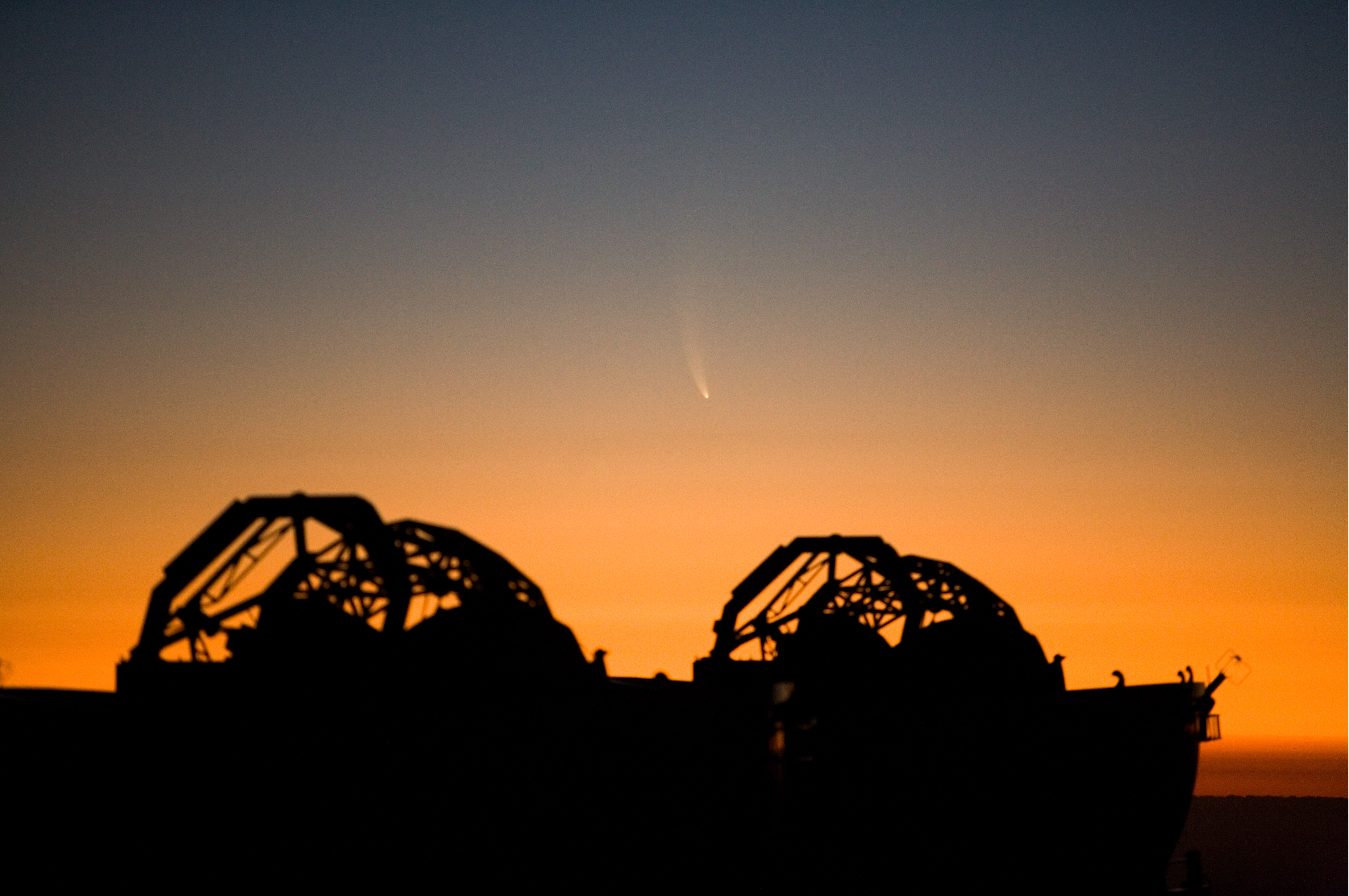 Comet McNaught with its broad curved tail setting over ESO's Paranal Observatory in Chile